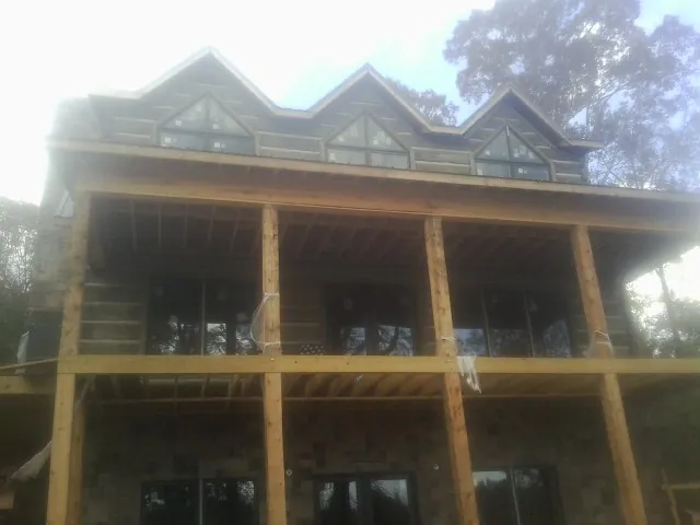 Dormers and porch framing on a large log home under construction — Roof Coating work by our crew in Skamokawa